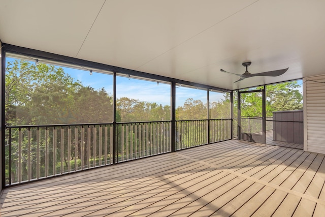 unfurnished sunroom featuring ceiling fan and a healthy amount of sunlight