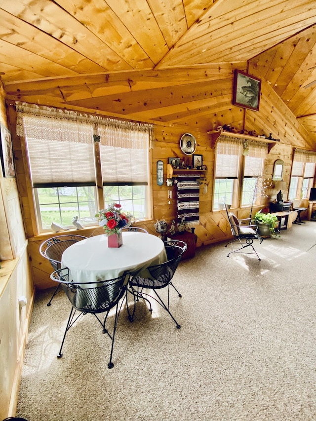 dining area featuring wooden walls, plenty of natural light, carpet flooring, and wooden ceiling