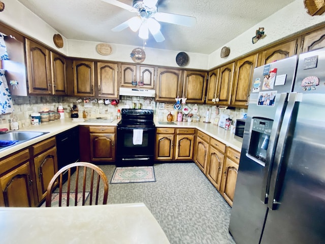 kitchen with a textured ceiling, black electric range oven, ceiling fan, under cabinet range hood, and stainless steel fridge