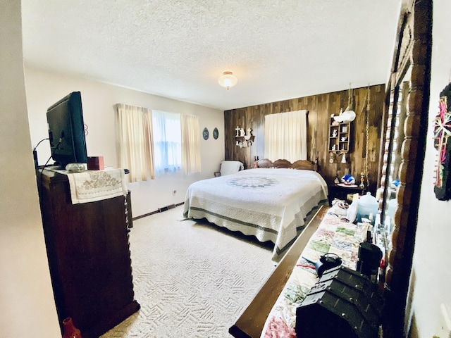 carpeted bedroom featuring a textured ceiling and wood walls