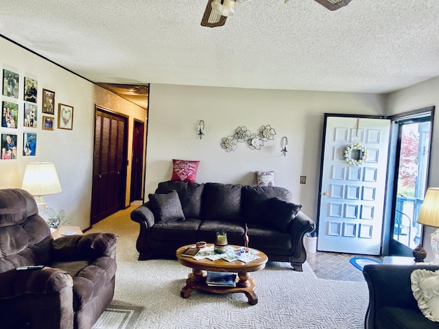 living room with a textured ceiling, ceiling fan, and light carpet