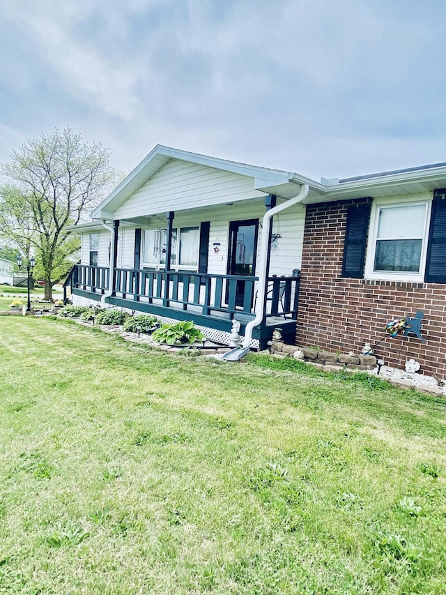 ranch-style home featuring brick siding, a porch, and a front lawn