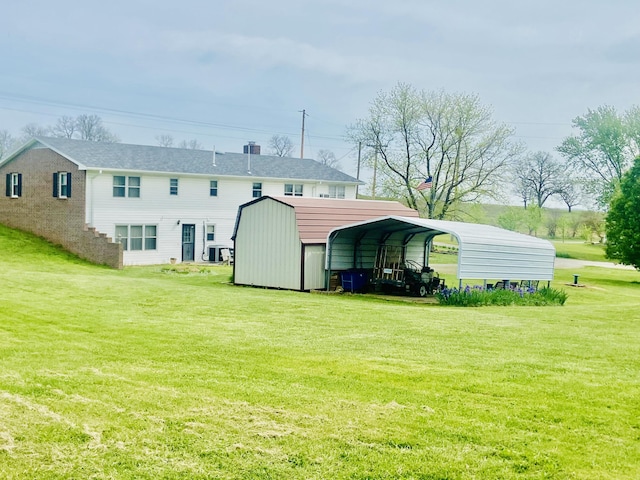 back of property with a detached carport and a lawn