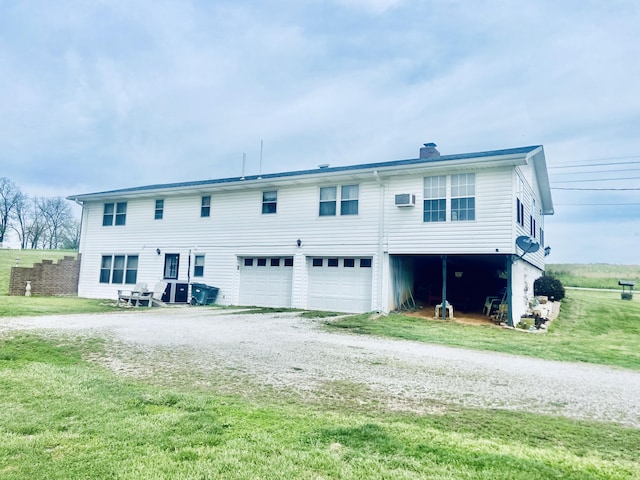 view of front of property with a chimney, a front lawn, driveway, and an attached garage
