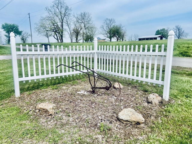 view of gate featuring fence and a lawn