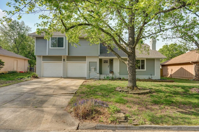 split level home featuring a chimney, brick siding, a front yard, concrete driveway, and an attached garage