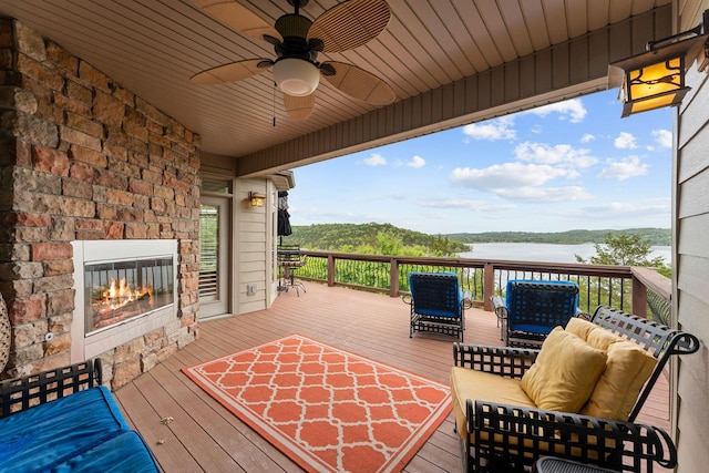 46 Wild Rose Ln, Lampe, MO 65681 - deck with a ceiling fan, an outdoor stone fireplace, and a water view