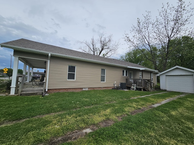 rear view of property featuring a garage, an outbuilding, and a lawn