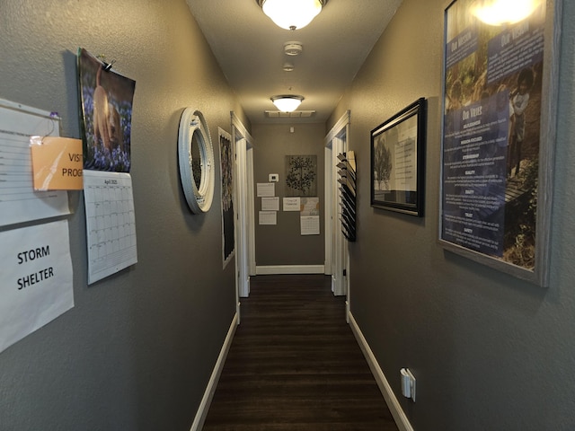 corridor featuring wood finished floors and baseboards