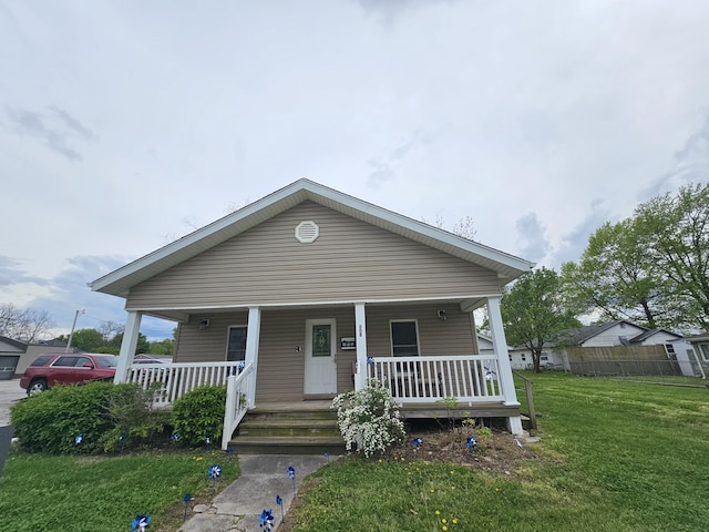 view of front of property featuring a porch, a front lawn, and fence