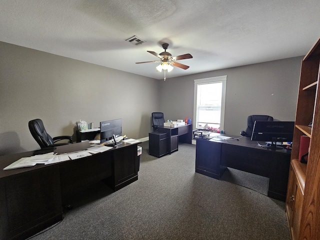 office space with a textured ceiling, visible vents, a ceiling fan, and carpet flooring