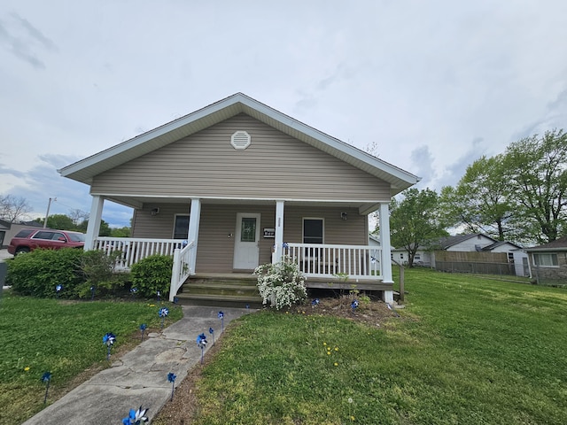 bungalow-style home with a porch, a front lawn, and fence