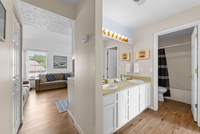 520 Abby Ln Unit 8, Branson, MO 65616 - ensuite bathroom featuring toilet, wood finished floors, double vanity, and shower / tub combo with curtain