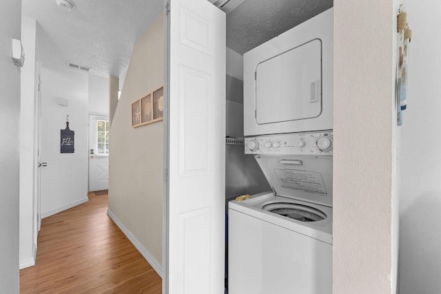 520 Abby Ln Unit 8, Branson, MO 65616 - washroom featuring estacked washer and dryer, light wood-style flooring, baseboards, and a textured ceiling