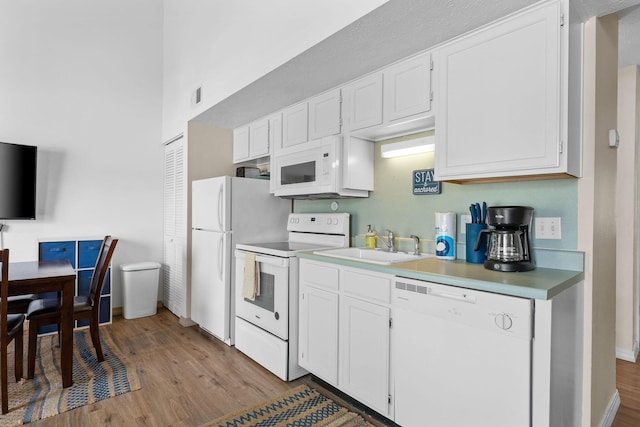 520 Abby Ln Unit 8, Branson, MO 65616 - kitchen with white appliances, a sink, light wood-style floors, white cabinets, and a towering ceiling