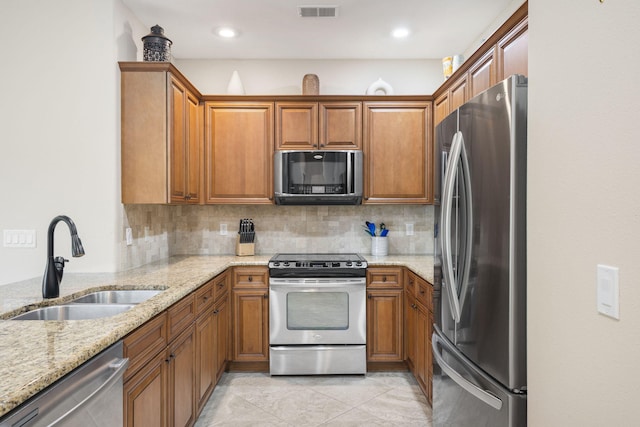 140 S Tuscany Dr Unit C, Hollister, MO 65672 - kitchen with appliances with stainless steel finishes, tasteful backsplash, brown cabinets, and a sink