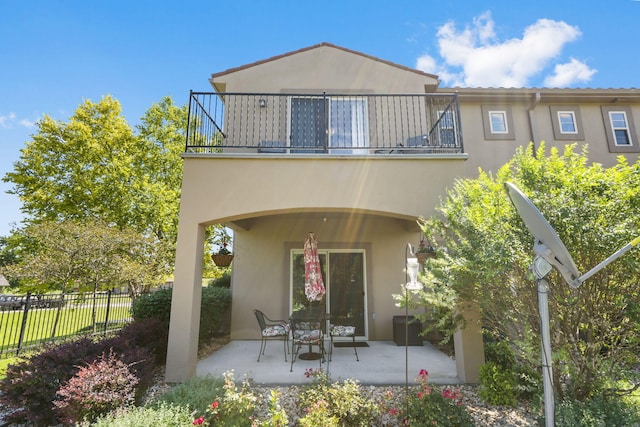 140 S Tuscany Dr Unit C, Hollister, MO 65672 - back of house with fence, stucco siding, and a balcony