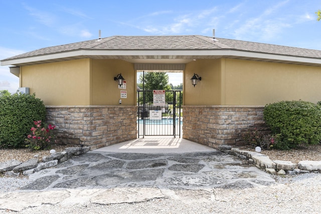 140 S Tuscany Dr Unit C, Hollister, MO 65672 - property entrance with fence, stone siding, stucco siding, and a gate