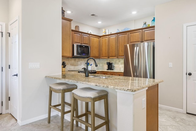 140 S Tuscany Dr Unit C, Hollister, MO 65672 - kitchen featuring light stone countertops, decorative backsplash, appliances with stainless steel finishes, visible vents, and a peninsula