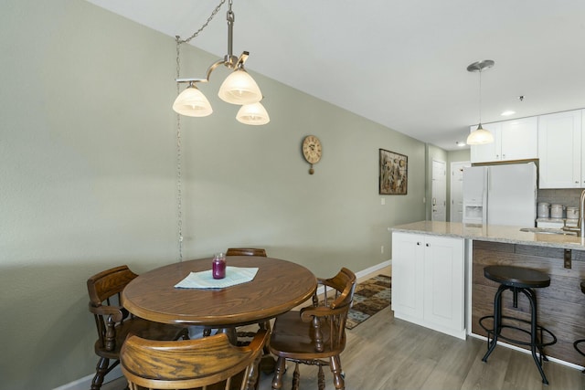 dining area with light wood-style flooring and baseboards