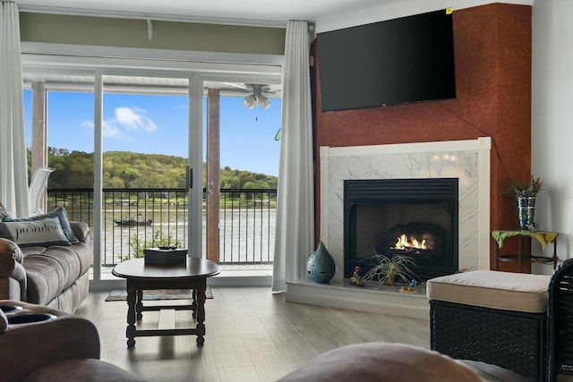 living room with wood finished floors, a ceiling fan, and a fireplace