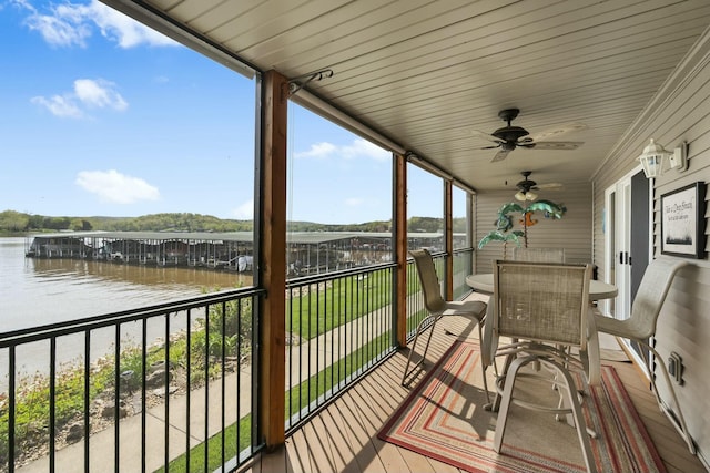 exterior space with outdoor dining area, a ceiling fan, and a water view