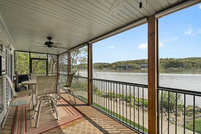 sunroom featuring ceiling fan, a water view, and plenty of natural light