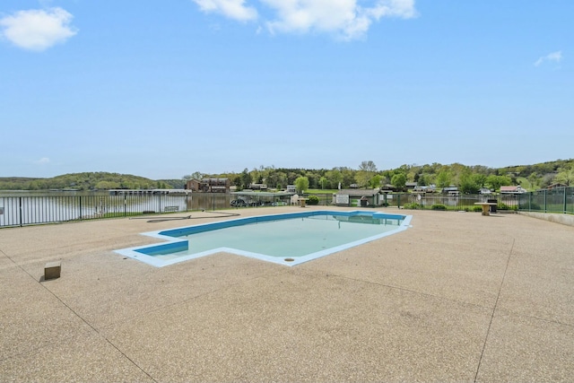 view of swimming pool featuring a water view and fence