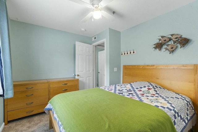 bedroom with visible vents, a ceiling fan, and light colored carpet