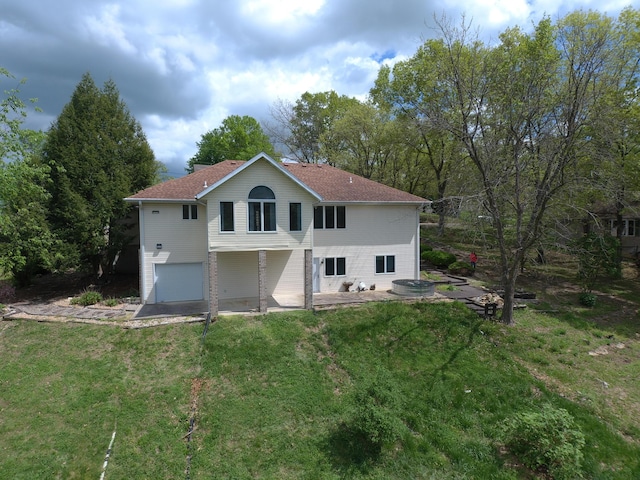 rear view of house featuring a garage and a yard