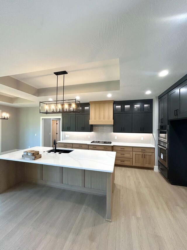 5958 S Clay Ave, Springfield, MO 65810 - kitchen featuring stainless steel appliances, light wood-style flooring, a sink, glass insert cabinets, and decorative backsplash