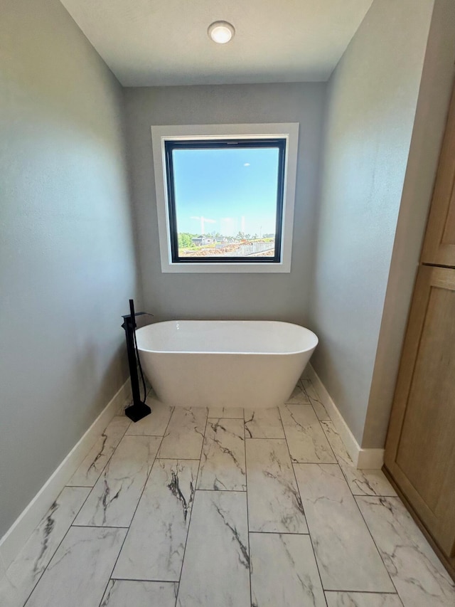 5958 S Clay Ave, Springfield, MO 65810 - full bathroom with marble look tiles, baseboards, and a freestanding tub
