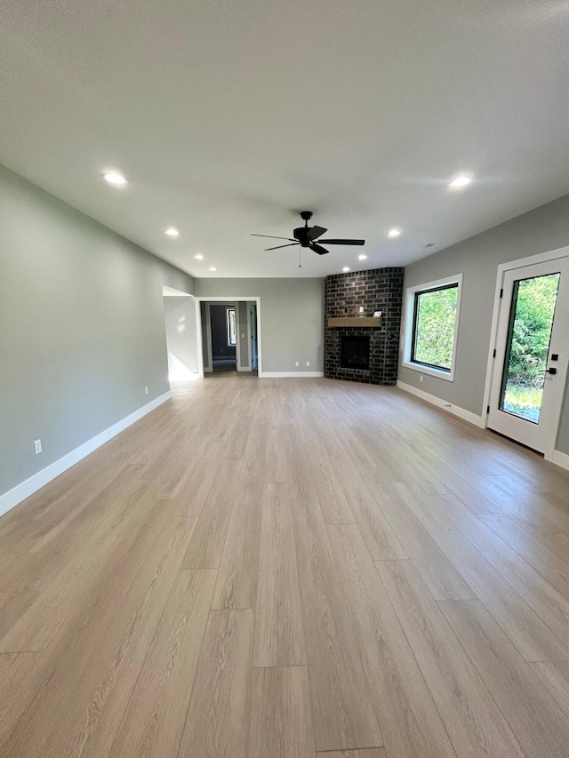 5958 S Clay Ave, Springfield, MO 65810 - unfurnished living room featuring light wood-style flooring, a brick fireplace, baseboards, and recessed lighting