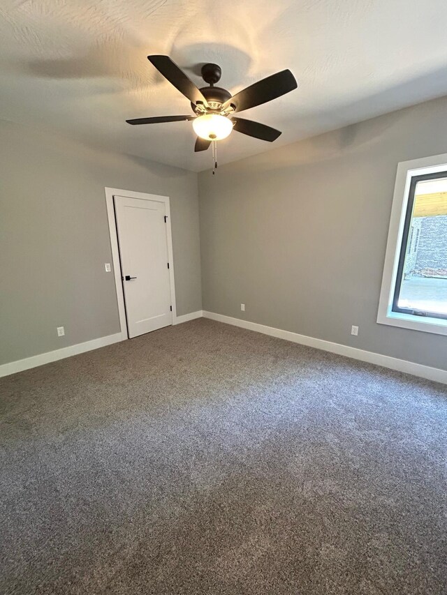 5958 S Clay Ave, Springfield, MO 65810 - spare room with baseboards, ceiling fan, and dark carpet