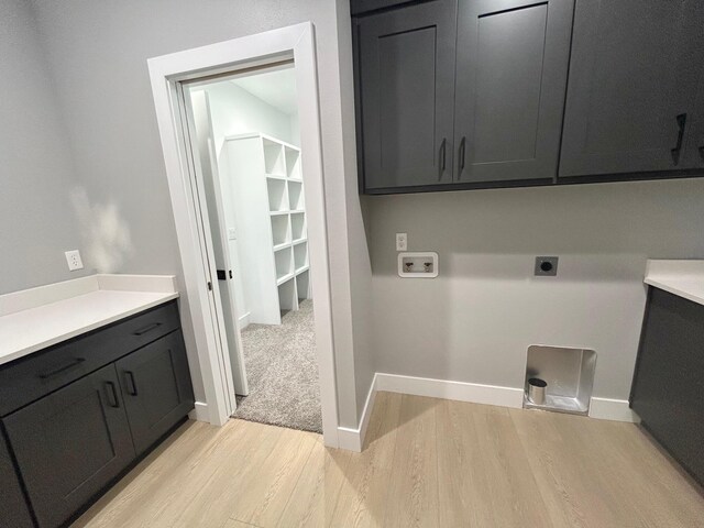 5958 S Clay Ave, Springfield, MO 65810 - laundry room with cabinet space, hookup for an electric dryer, light wood-style flooring, hookup for a washing machine, and baseboards