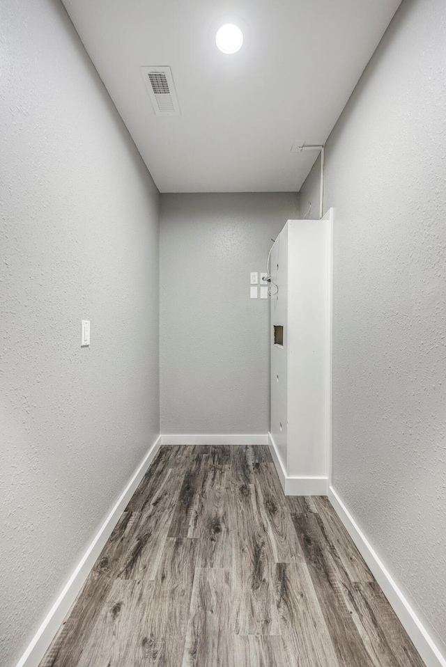 interior space featuring visible vents, wood finished floors, and baseboards