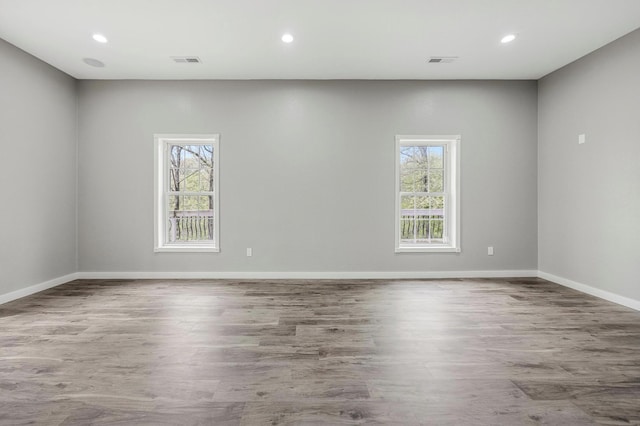 spare room featuring recessed lighting, visible vents, wood finished floors, and baseboards