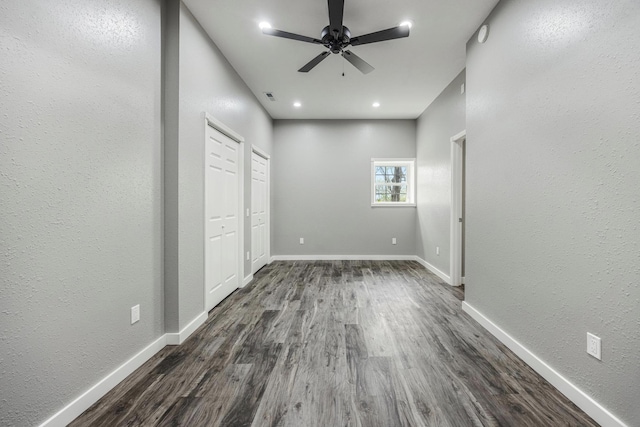 spare room with recessed lighting, dark wood-style flooring, ceiling fan, a textured wall, and baseboards