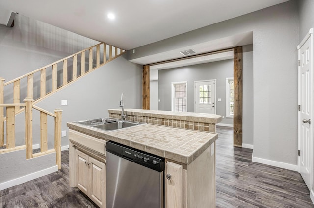 kitchen with stainless steel dishwasher, visible vents, a sink, and baseboards