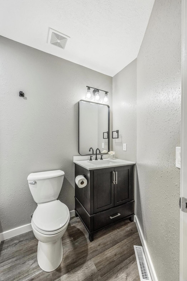 bathroom featuring wood finished floors, visible vents, and baseboards