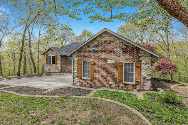 view of front of property with stone siding and a patio area