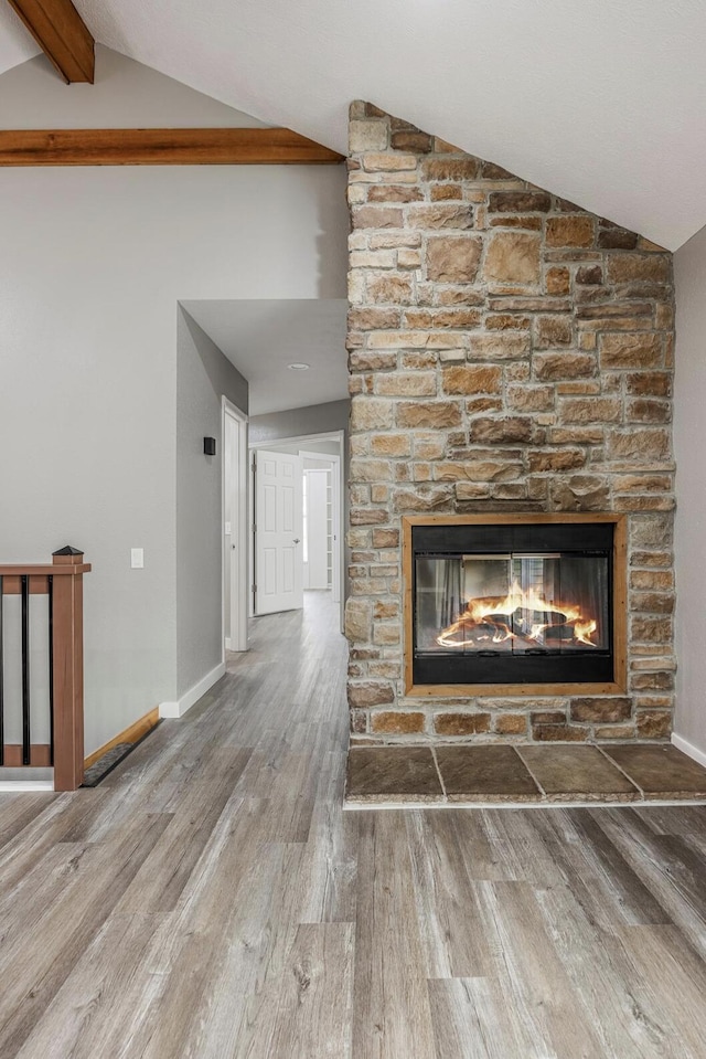 details with a fireplace, wood finished floors, beamed ceiling, and baseboards