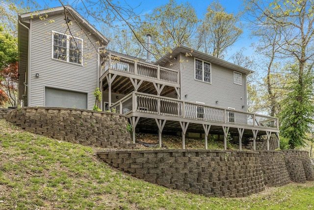 rear view of property featuring a deck and a garage