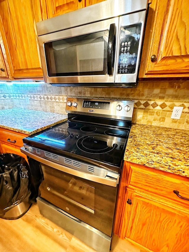 kitchen with tasteful backsplash, brown cabinetry, and stainless steel appliances