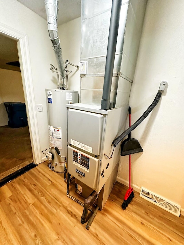 utilities with water heater and visible vents