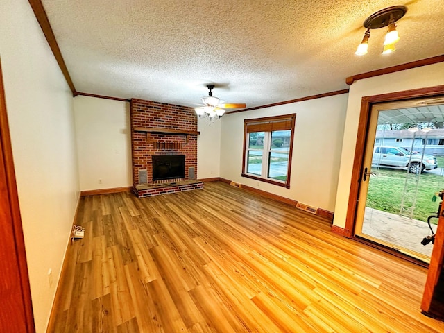 unfurnished living room with a wealth of natural light, visible vents, crown molding, and light wood finished floors