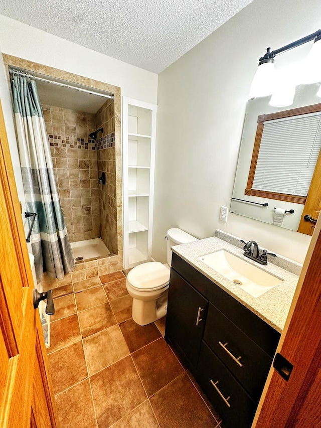 full bath featuring tile patterned floors, toilet, vanity, a stall shower, and a textured ceiling