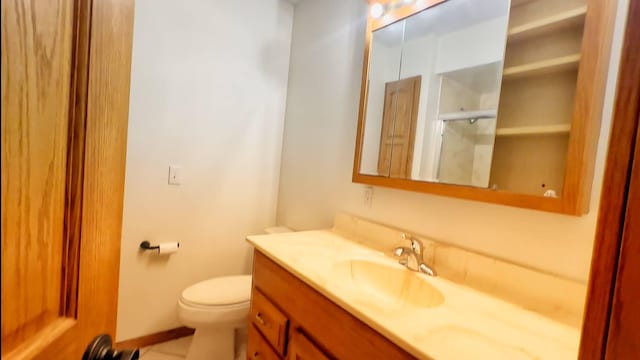 bathroom featuring vanity, toilet, a shower with shower door, baseboards, and tile patterned flooring