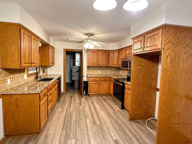 213 W Charles St, Republic, MO 65738 - kitchen with stainless steel appliances, a sink, brown cabinets, and light wood finished floors