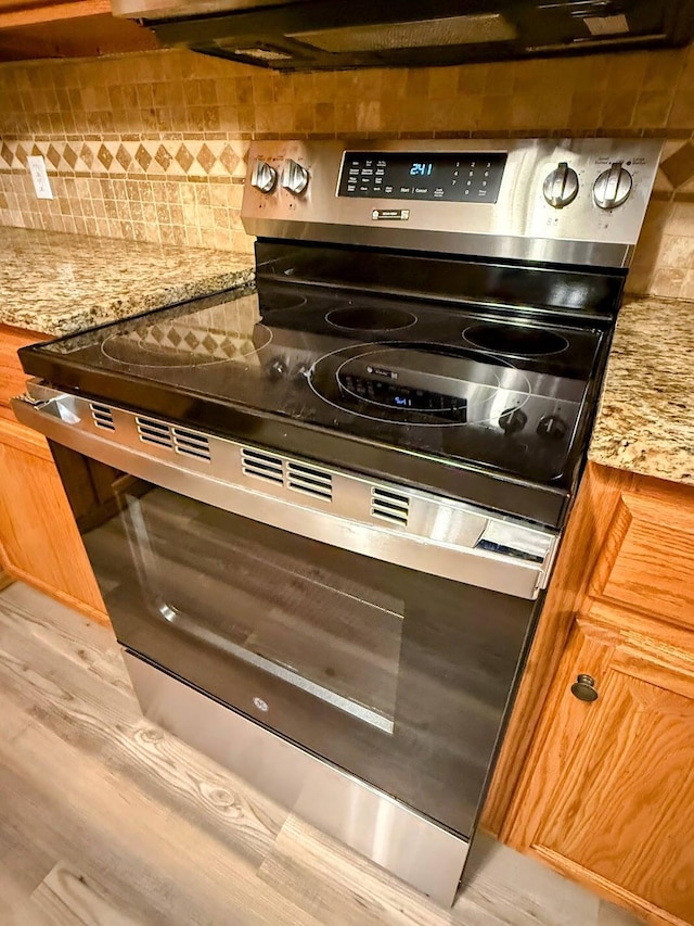 213 W Charles St, Republic, MO 65738 - kitchen view of stainless steel electric range oven, decorative backsplash, and light stone countertops